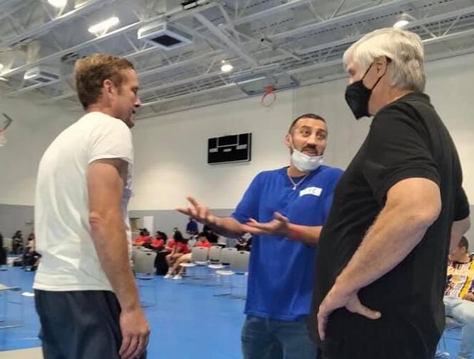 Boxing instructor Lee Anderson (left) speaks with coaches before the event